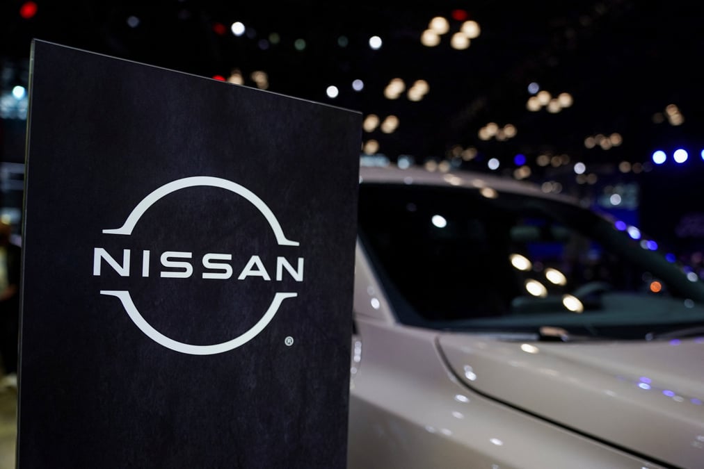 Un logo nissan a cote d'un vehicule lors du salon international de l'automobile de new york
