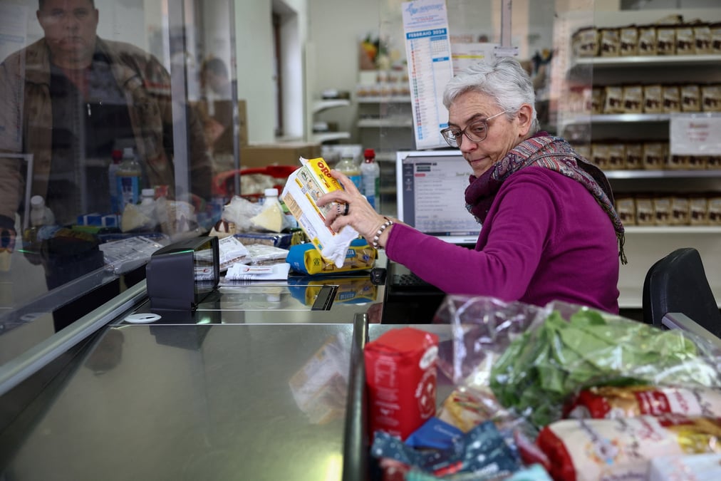 Une femme travaille a la caisse d'un supermarche