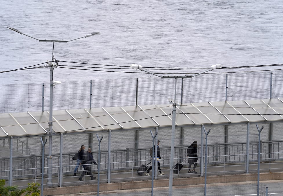 Des gens traversent un pont au point de passage frontalier avec la russie a narva, en estonie