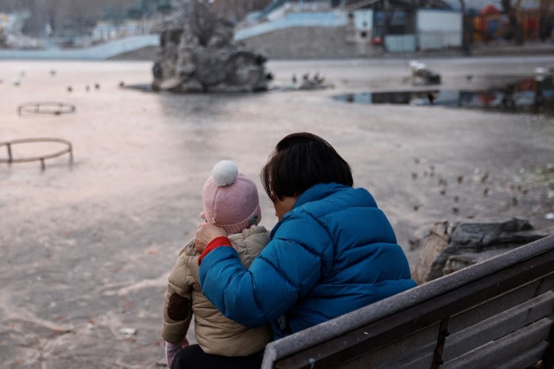 Une femme et un enfant assis dans un parc a pekin