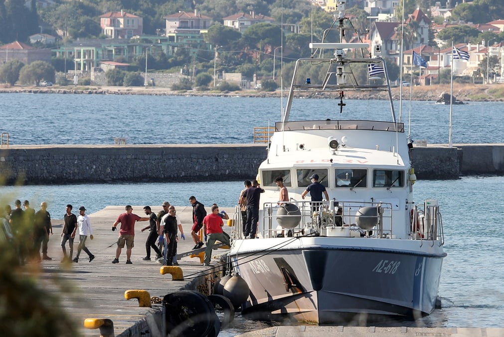 Des migrants secourus debarquent d'un navire au port de mytilene