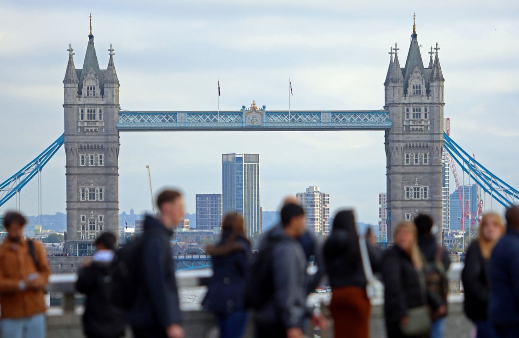 Des personnes marchent sur le london bridge dans le quartier financier de la city de londres
