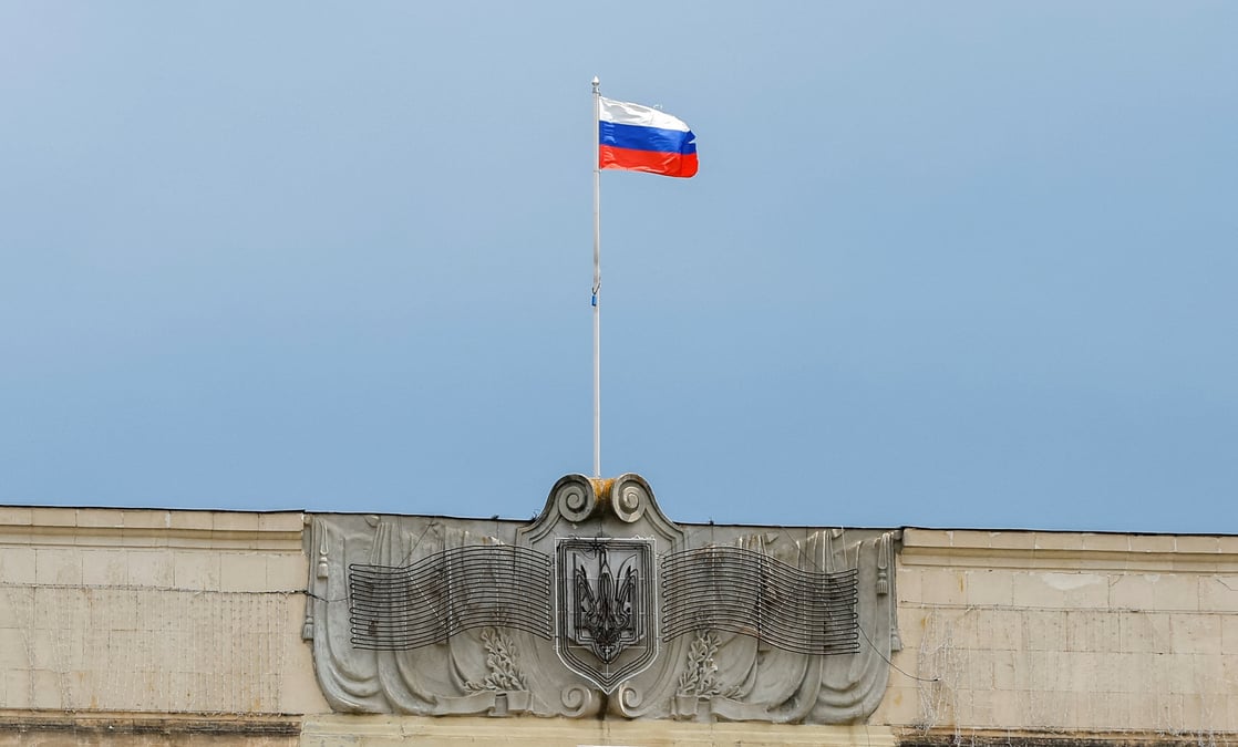 Un drapeau russe flotte au-dessus des armoiries ukrainiennes demantelees dans la ville de kherson