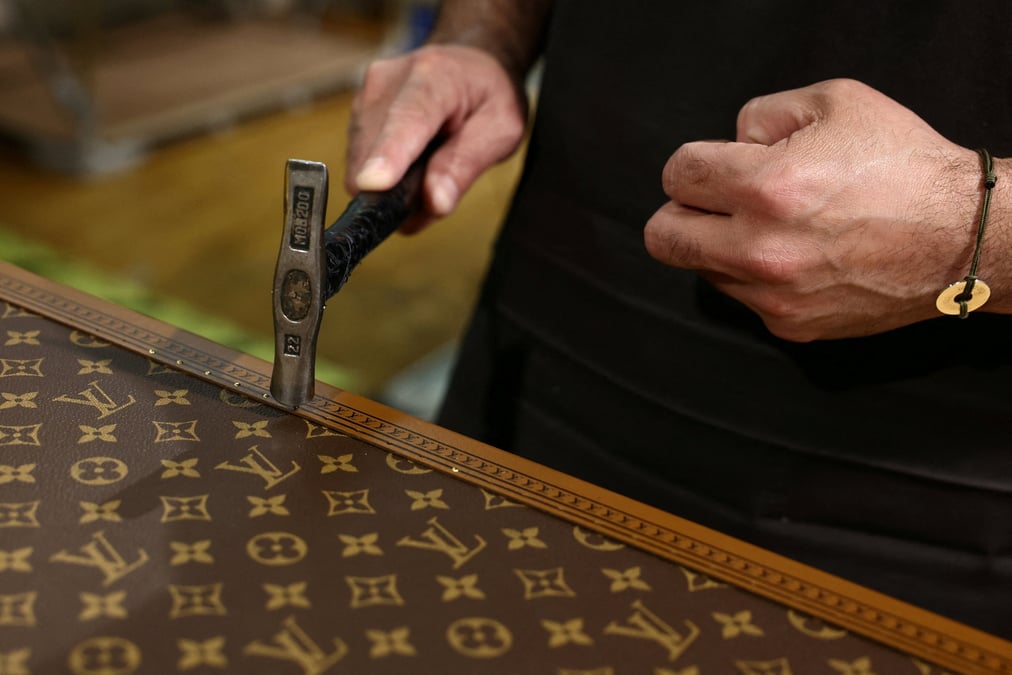 Un employe travaille sur la fabrication d'une malle louis vuitton