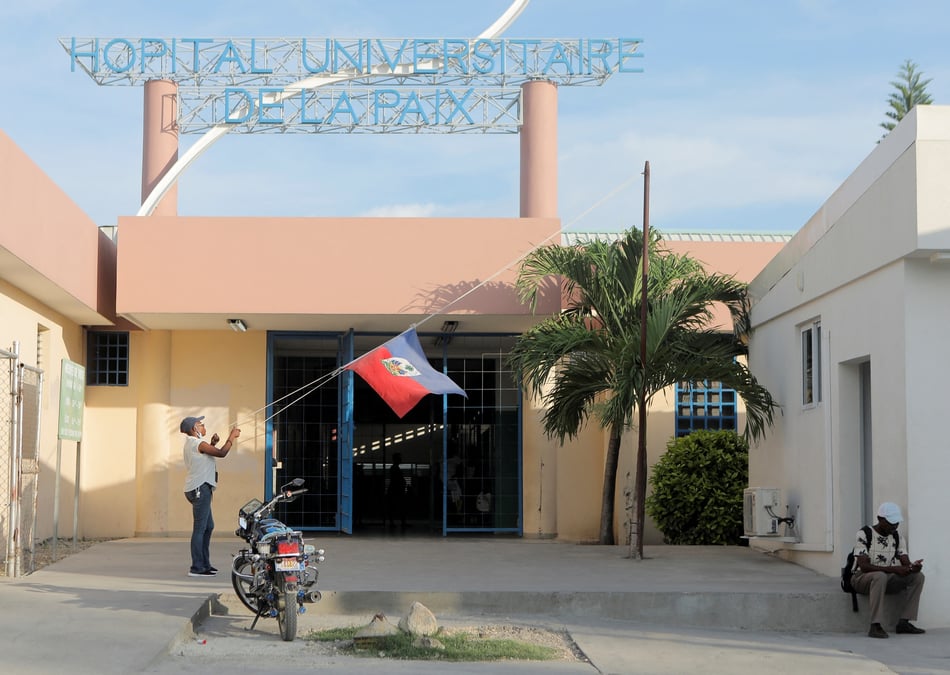 Une femme abaisse le drapeau d'haiti dans un hopital de port-au-prince