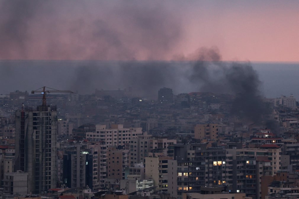 De la fumee s'eleve dans la banlieue sud de beyrouth au coucher du soleil, apres des frappes aeriennes israeliennes, dans le cadre des hostilites entre le hezbollah et les forces israeliennes, vue de sin el fil, liban.