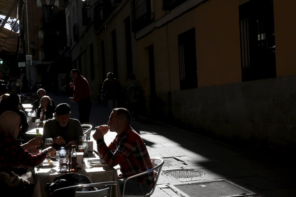 Des personnes dejeunent a des tables en plein air dans un restaurant du centre de madrid