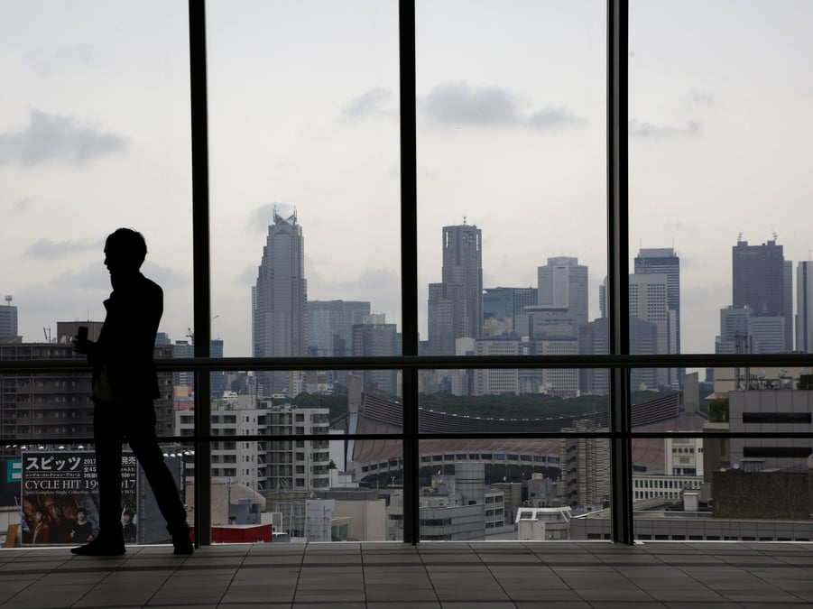 La silhouette d'un homme devant les gratte-ciel de tokyo
