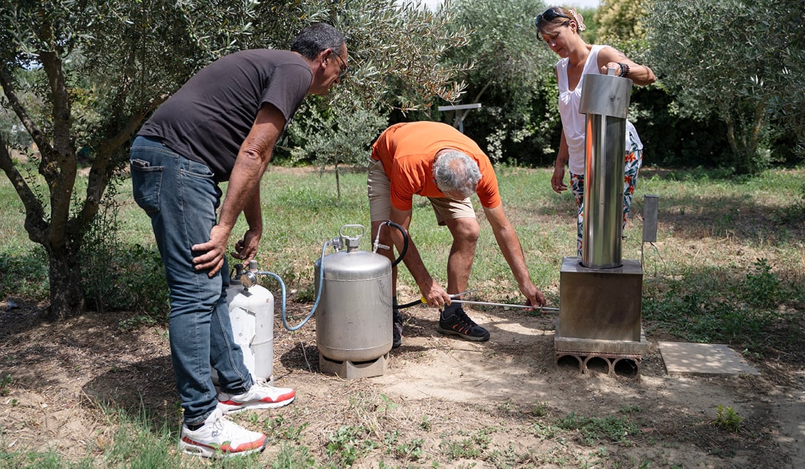 Frédéric Jouffret (au centre) effectue une démonstration du générateur pour l'ensemencement des nuages dans le jardin de Jean-Claude Micol (à gauche) en présence de Sandra Scavennec de Previgrêle, à Carpentras, juillet 2024.