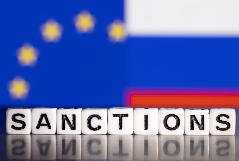 Illustration du mot "sanctions" devant les drapeaux de l'union europeenne et de la russie