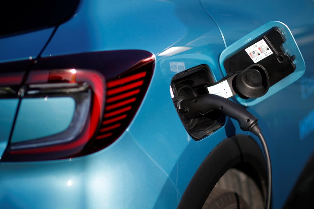Une voiture hybride renault captur est connectee a une borne de recharge chez un concessionnaire des sorinieres