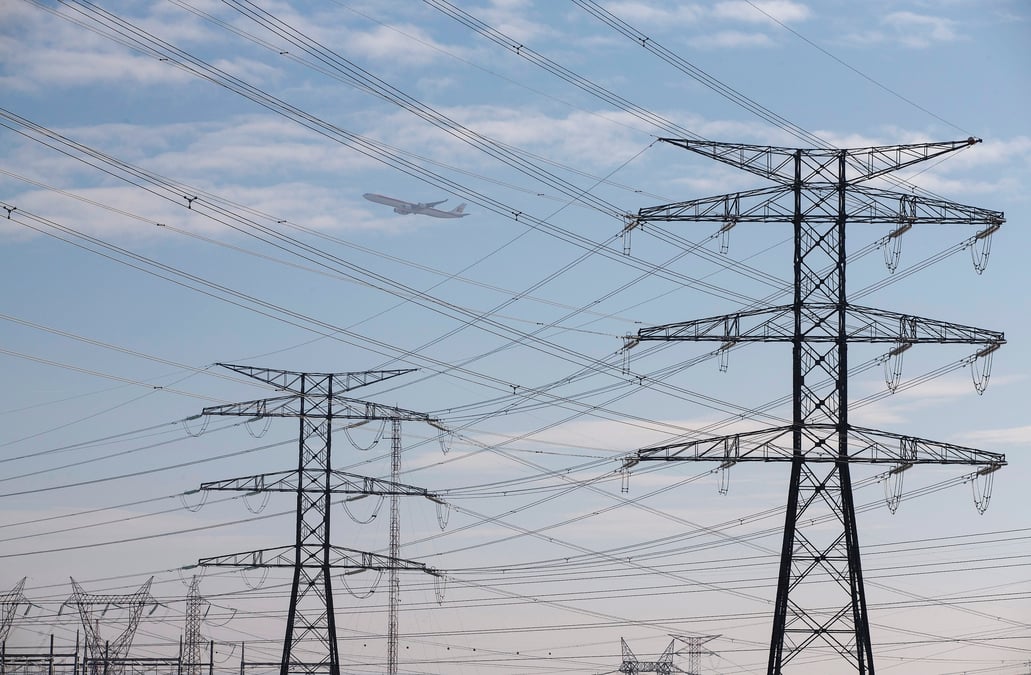 An iberia jet flies over power lines outside madrid
