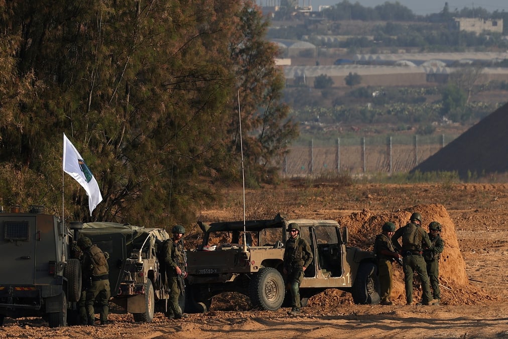 Des soldats israeliens se tiennent a cote de vehicules militaires pres de la frontiere entre israel et la bande de gaza, dans le cadre du conflit entre israel et le hamas