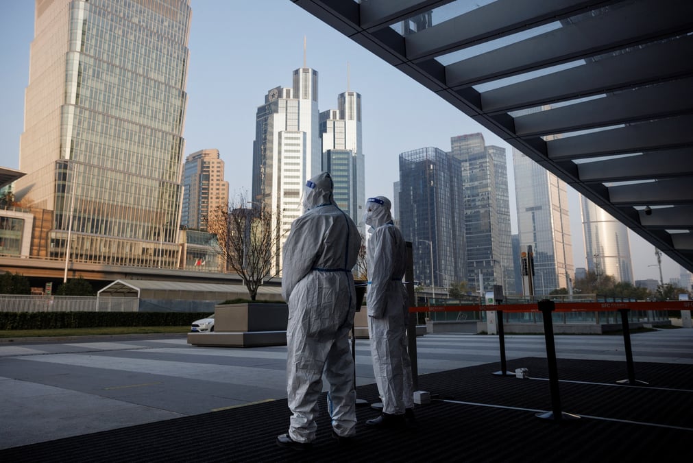 Les autorites en tenue de protection gardent l'entree d'un immeuble de bureaux a pekin, en chine
