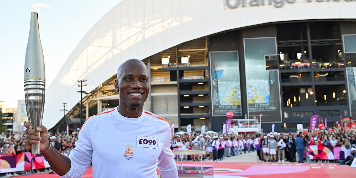 Le footballeur Didier Drogba tenant la flamme olympique à Marseille, le 9 mai.