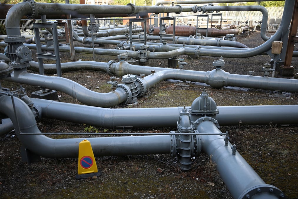 Photo des sections de gazoduc a cote d'un reservoir de gaz desaffecte a manchester