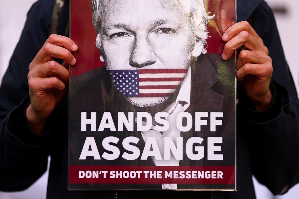 Un soutien de julian assange montre une pancarte avec son visage devant le tribunal de westminster a londres
