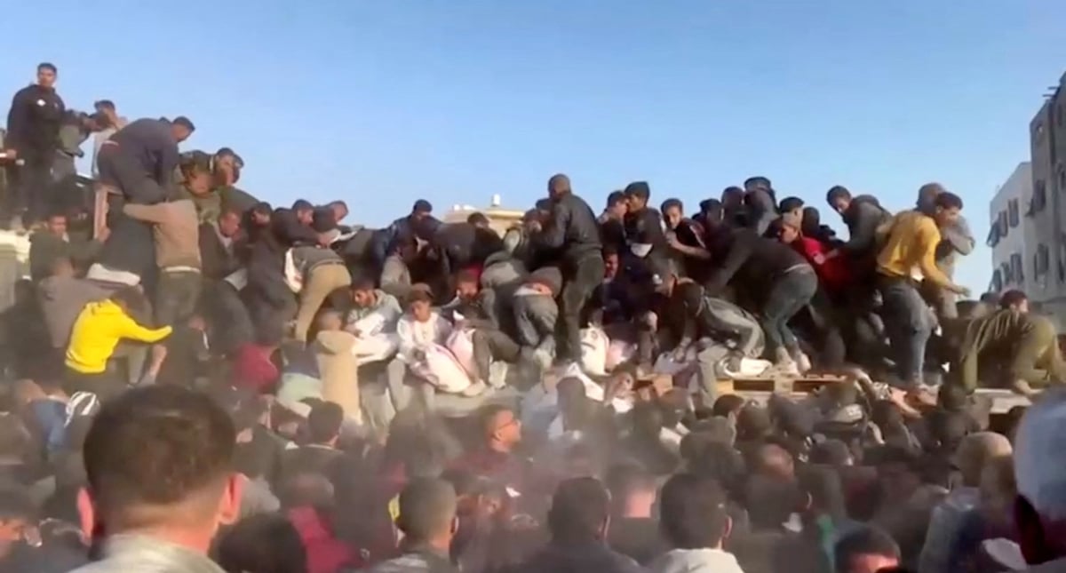 Des personnes se precipitent vers un camion transportant de l'aide humanitaire dans le quartier d'al zaytoun, dans la ville de gaza