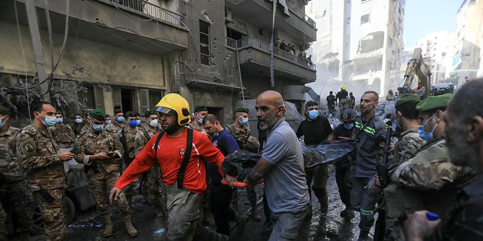 Des soldats de l'armée libanaise regardent les sauveteurs retirer le corps d'une victime des décombres, suite à une frappe aérienne israélienne qui a visé le quartier de Basta à Beyrouth, le 23 novembre 2024.