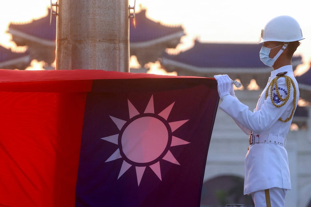 Photo d'archives: les gardes d'honneur abaissent le drapeau de taiwan pendant les heures de coucher du soleil sur la place de la liberte a taipei