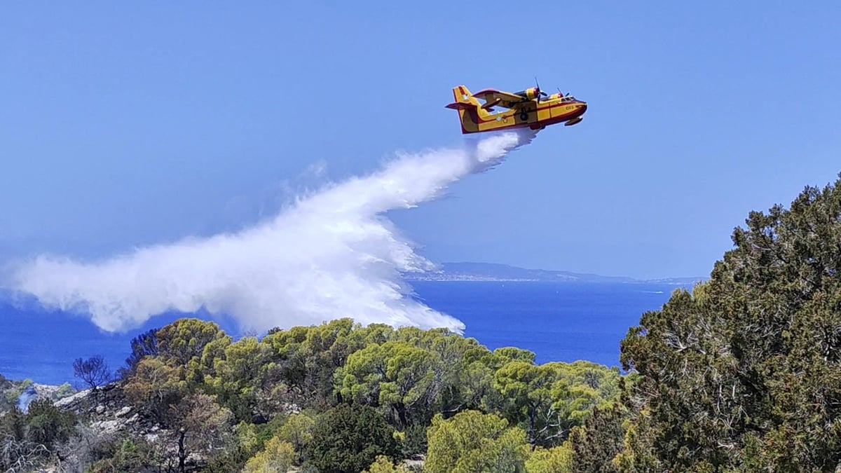 Un avion de lutte contre les incendies largue de l'eau sur une zone touchee par un feu de foret sur l'ile d'hydra