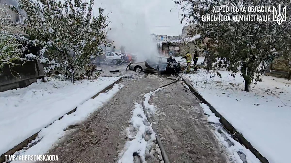 Les premiers intervenants travaillent pres de voitures incendiees apres une frappe d'artillerie russe meurtriere a kherson, en ukraine