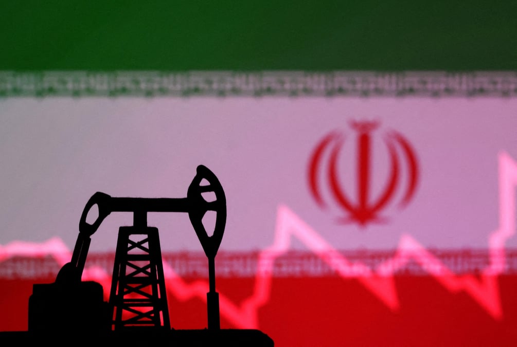 Le drapeau iranien avec un graphique boursier et un modele miniature de verin de pompe a petrole sont vus dans cette