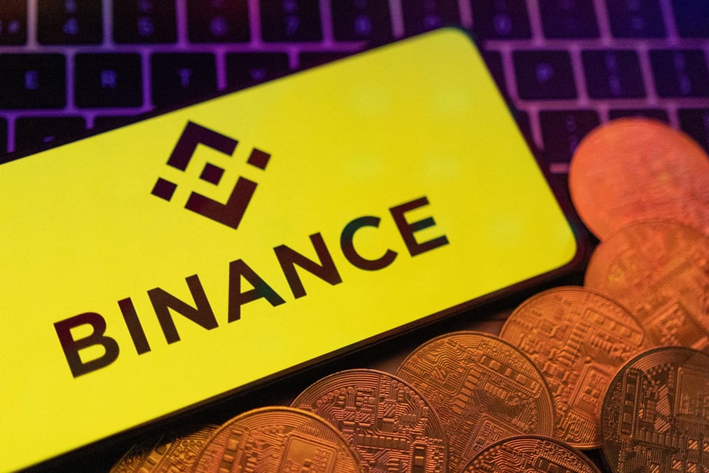 Une illustration du logo binance et des crypto-monnaies