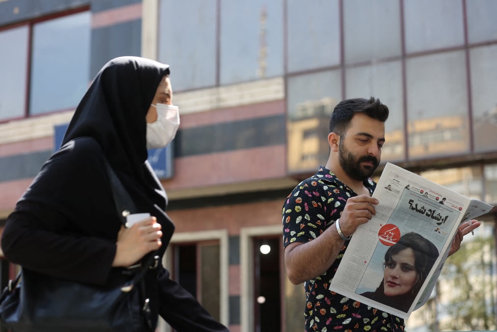 Un homme regarde un journal montrant mahsa amini, victime de la "police des moeurs" de la republique islamique d'iran, a teheran