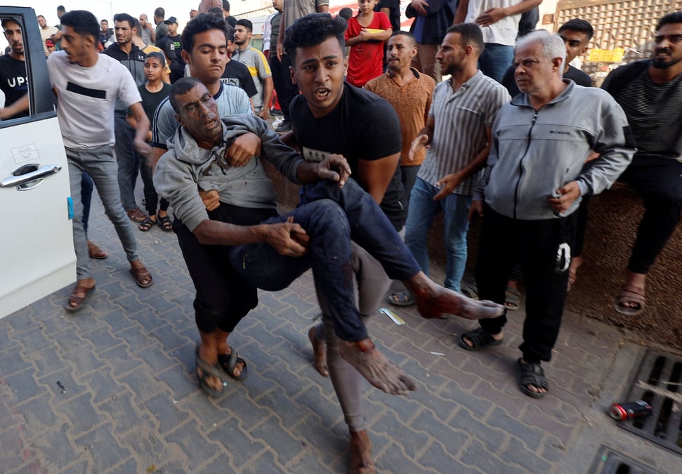 Des civils palestiniens portant un blesse apres une frappe israelienne a khan younis, au sud de gaza