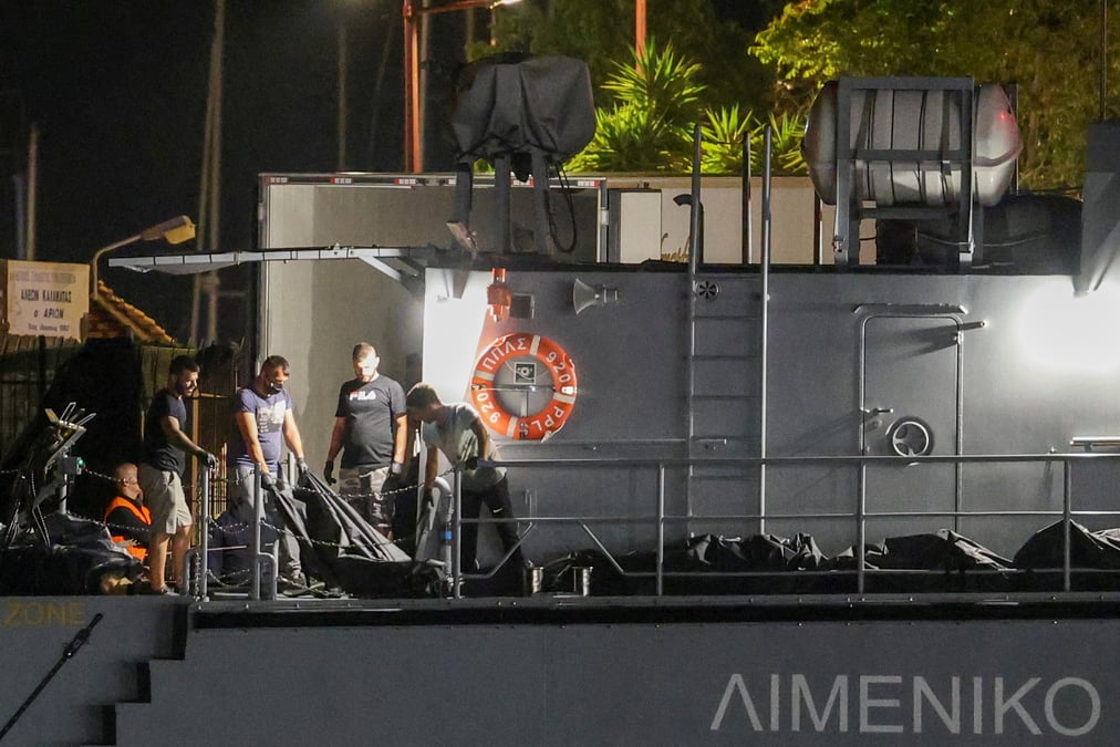 Des gardes cotiers grecs transferent des corps de migrants morts lors d'un naufrage