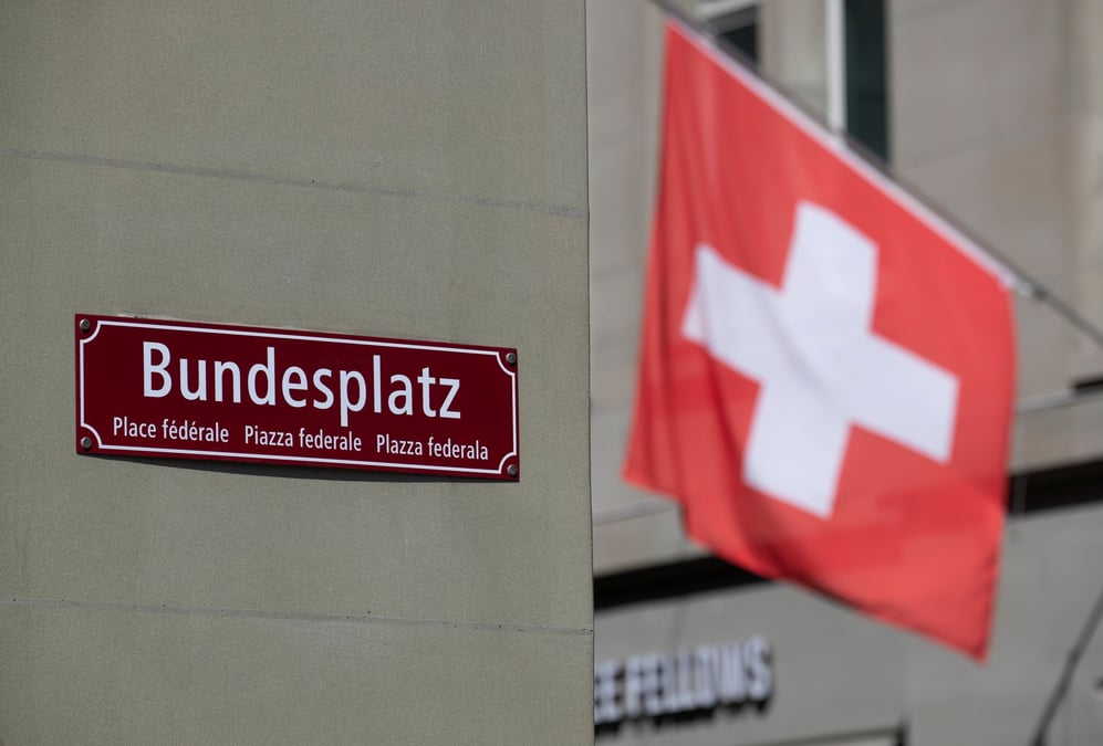 Un drapeau suisse devant le panneau de la place federale