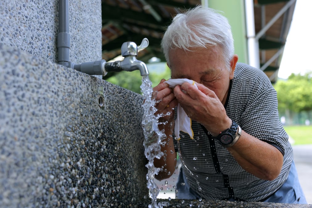 Une personne agee se rafraichie lors d'une journee de canicule