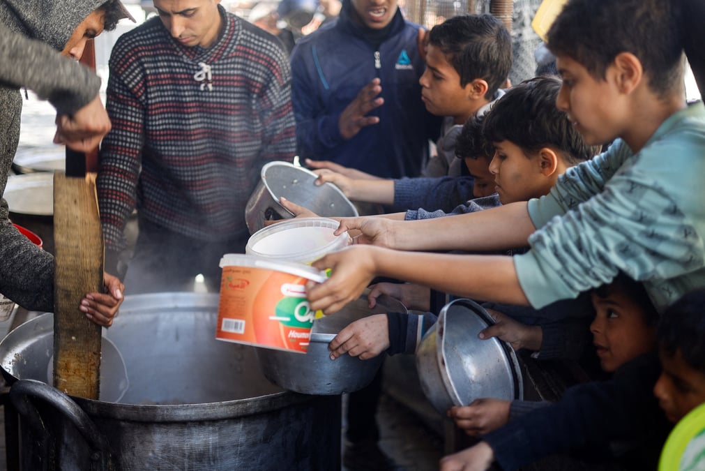 Des enfants palestiniens attendent de recevoir de la nourriture a rafah