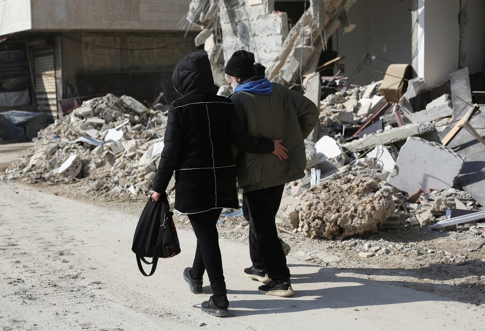 Des gens marchent pres des batiments endommages par un tremblement de terre a jableh, en syrie