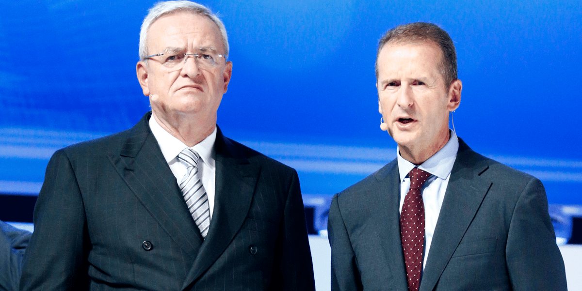 Sur cette photo qui date du 17 septembre 2015, Martin Winterkorn, alors PDG de Volkswagen, et Herbert Diess (à d.), président de Volkswagen Passenger Cars (et futur successeur), tiennent conférence lors du Salon automobile de Francfort de 2015, en présence de la chancelière allemande, Angela Merkel. Le lendemain, le vendredi 18 septembre, les autorités américaines contraignaient le constructeur à rappeler près de 500.000 véhicules, le menaçant de lourdes pénalités pour tricherie.