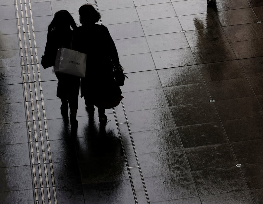Des femmes portant un sac de courses dans un quartier commercant de tokyo