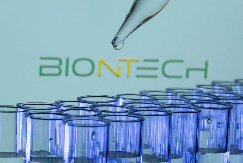 Illustration montrant des tubes a essai devant un logo biontech