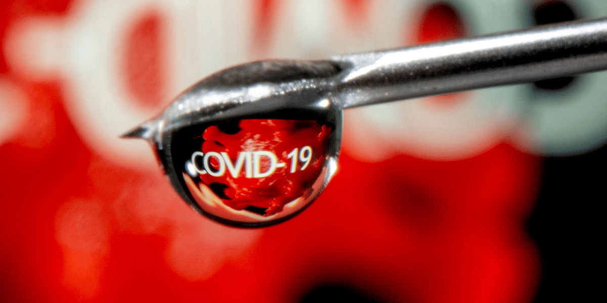 Le mot "covid-19" est reflete dans une goutte sur une aiguille de seringue dans cette illustration