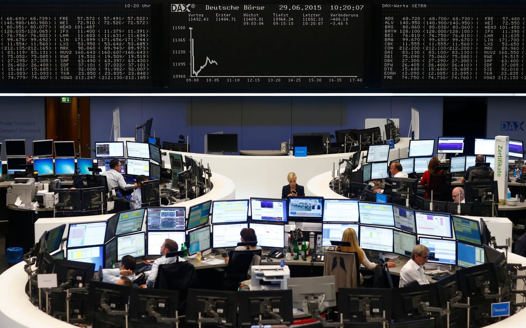 Des traders sont assis a leurs bureaux devant le tableau du dax a la bourse de francfort