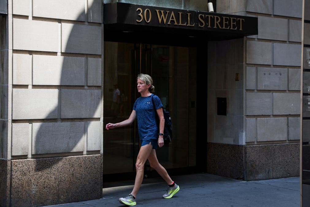 Une pietonne passe devant un batiment de wall street a new york
