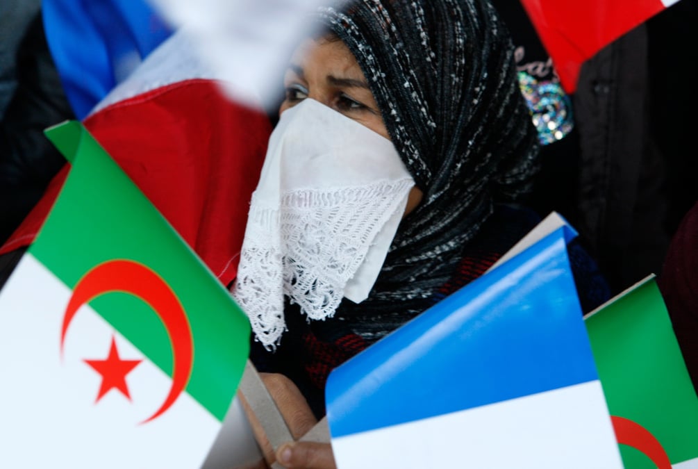 Une algerienne tenant des drapeaux algerien et francais