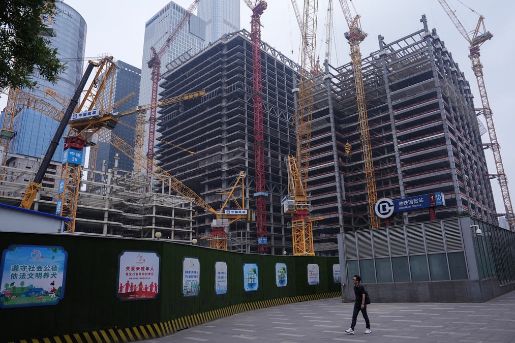 Une personne passe devant un chantier de construction dans le quartier central des affaires (cbd) de pekin.
