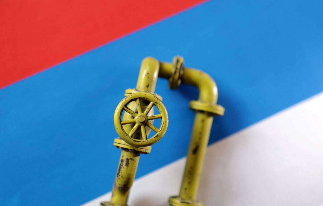 Un modele de pipeline de gaz naturel est place sur un drapeau russe dans cette illustration