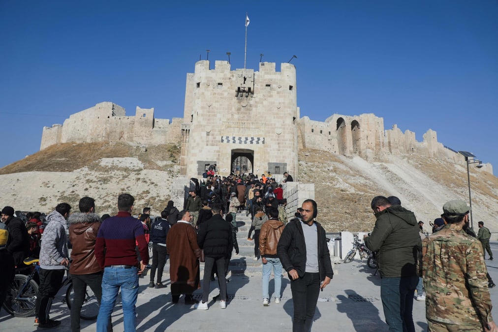 Des rebelles syriens posent devant la célèbre forteresse d'Alep, qui avait été sérieusement bombardé par l'aviation russe il y a cinq ans.