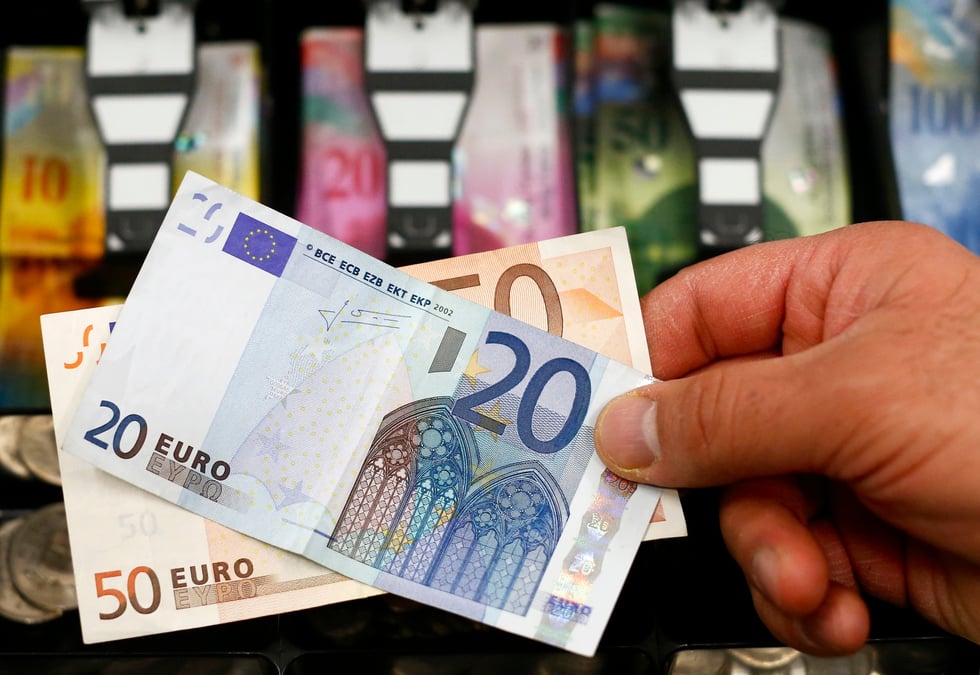 Des billets de banque devant un tiroir-caisse