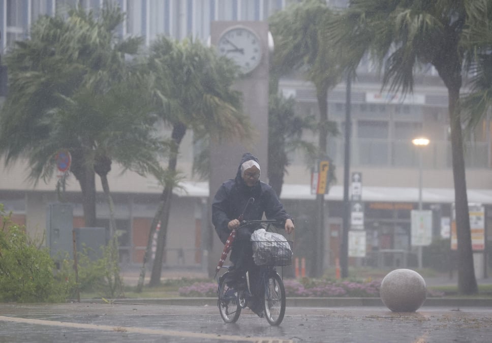 Un homme a velo passe sous les fortes pluies et le vent provoques par le typhon nanmadol a miyazaki