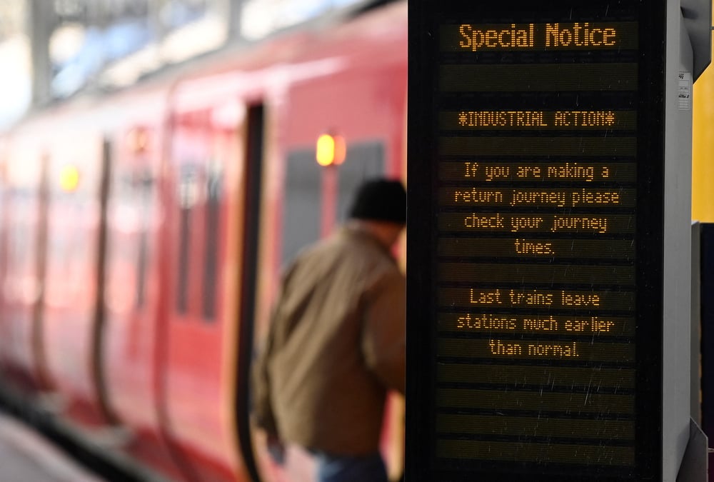 Un voyageur monte a bord d'un train a la gare de waterloo a londres, en grande-bretagne