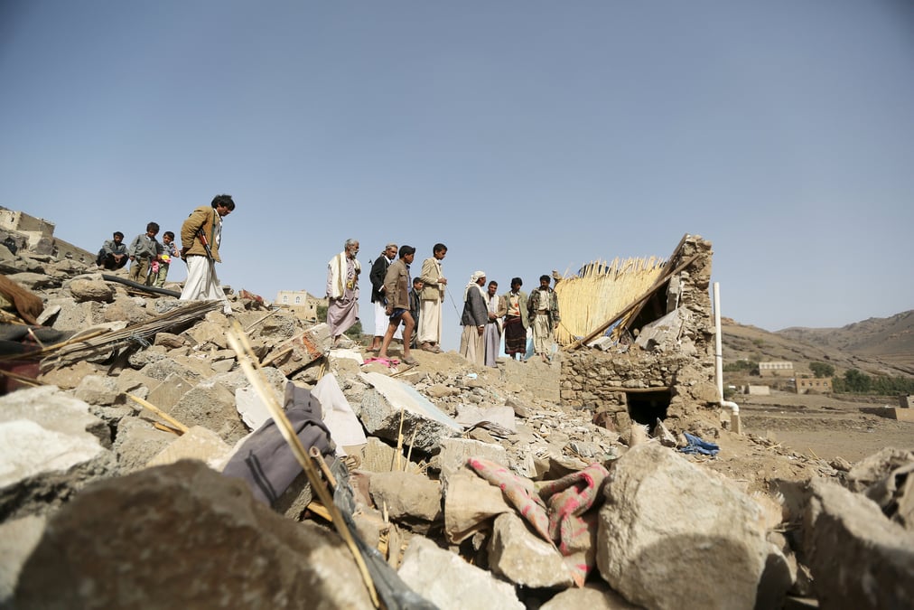 People gather on the wreckage of a house destroyed by an air strike in the bait rejal village west of yemen's capital sanaa