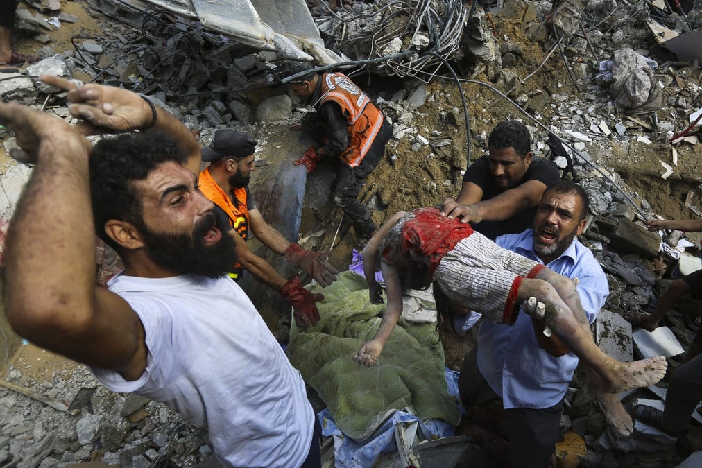 Des Palestiniens portent le corps d’un enfant mort après les frappes aériennes israéliennes sur Gaza, mardi.
